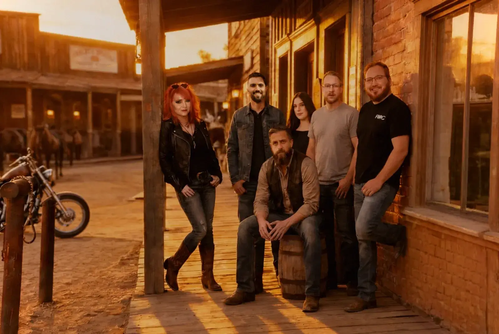 The FERO team gathered on a wooden western-style porch at sunset