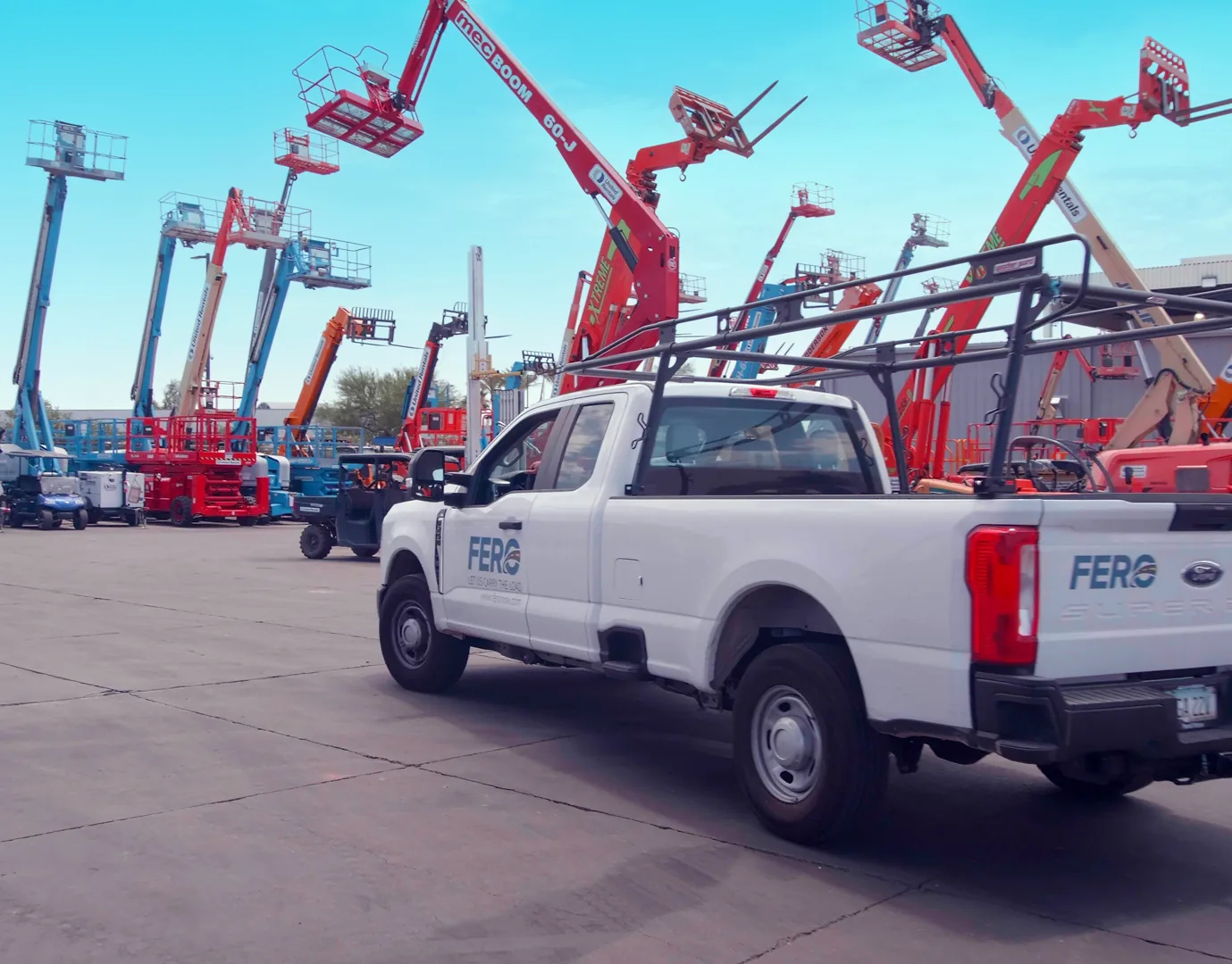 FERO pickup truck at an equipment rental yard with boom lifts and aerial work platforms